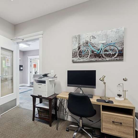 a room with a desk, chair, and bookshelf.