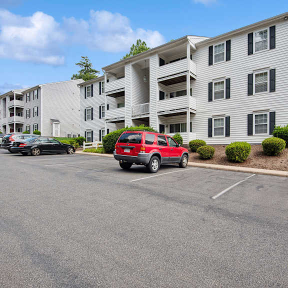 parking lot in front of a white apartment building.