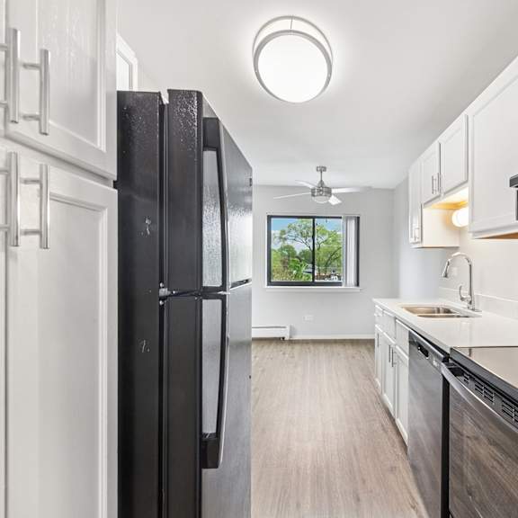 a modern kitchen with black appliances and white cabinets.