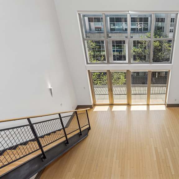 a room with a balcony and a window overlooking a building.