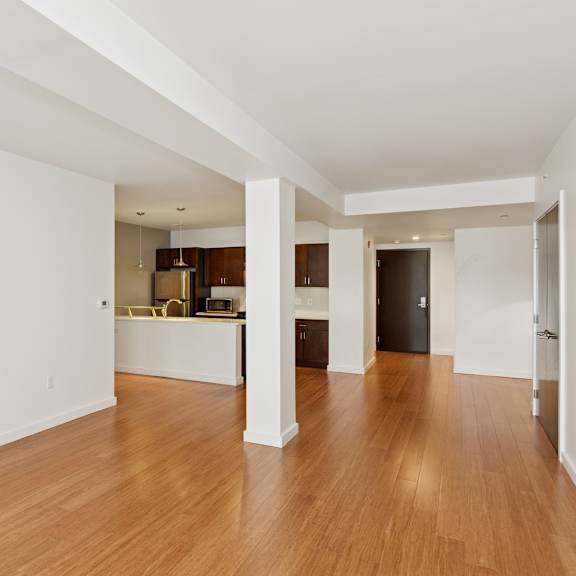a spacious room with wooden floors and white walls.