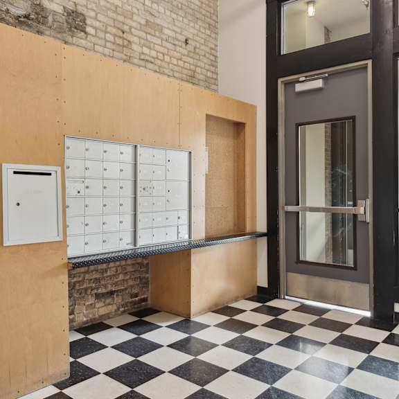 a lockers area in front of a door with a black and white checkered floorat gaar scott historic lofts, minneapolis, 55401