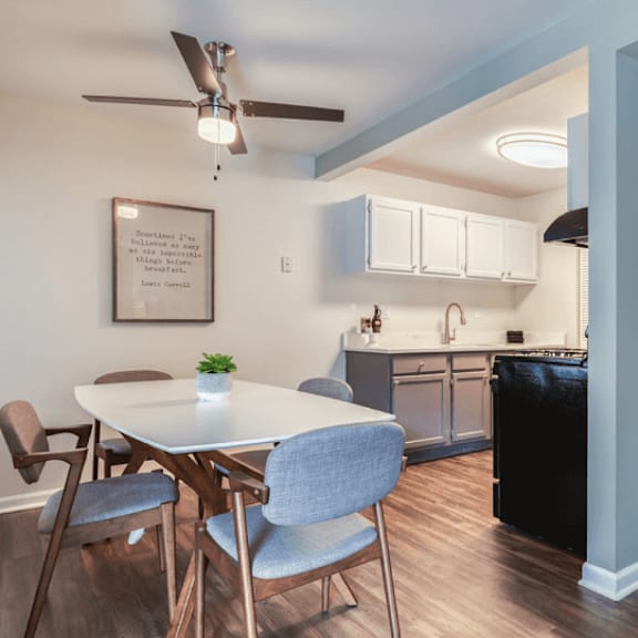 a dining area with a table and chairs and a kitchen in the background at the view apartments st charles, st charles, 60174