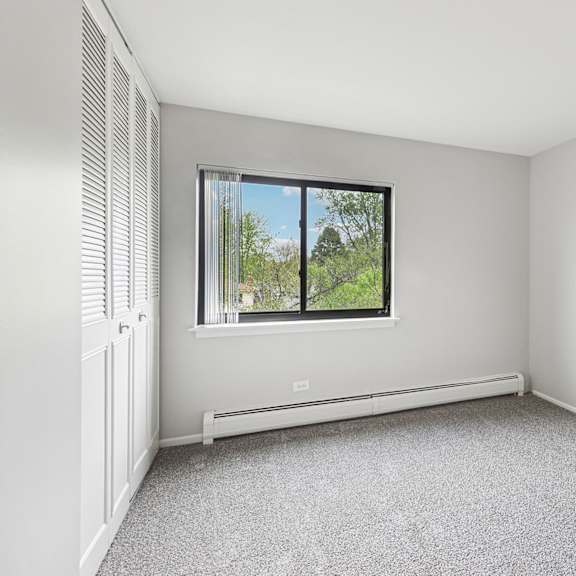 bedroom with a window and a radiator on the wall.