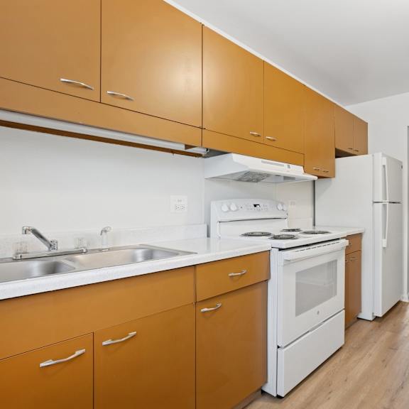 a kitchen with white appliances and wooden cabinets.