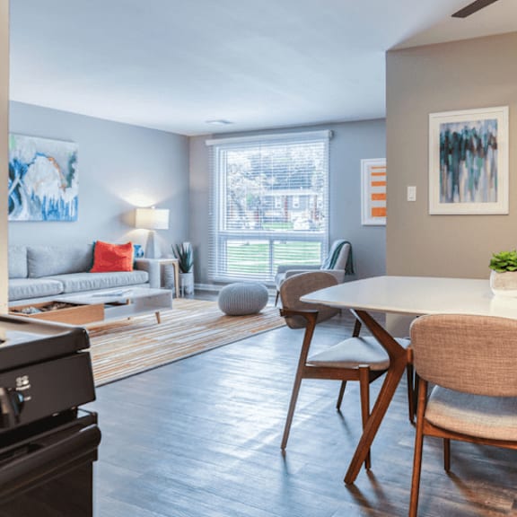 a dining area with a table and chairs and a living room in the background at the view apartments st charles, st charles, il, 60174