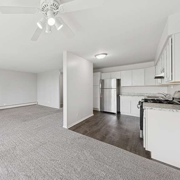 a spacious room with a ceiling fan and carpeted floor.