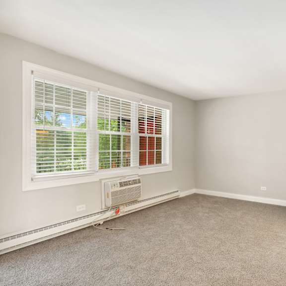 a bedroom with two windows and an air conditioner at the hinsdale, illinois