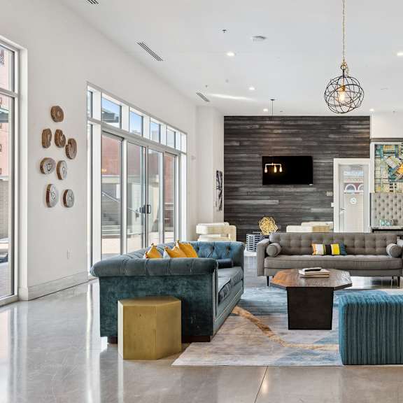 a modern living room with a dark wood accent wall and a large flat screen tv mounted above the fireplace.