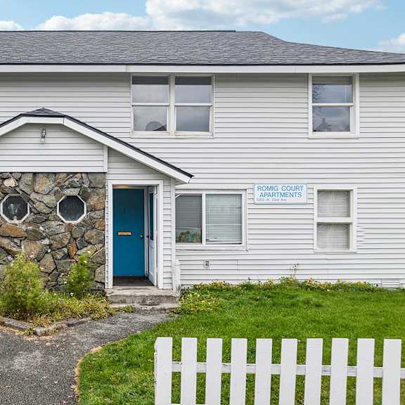 a white building with a blue door and a sign that says