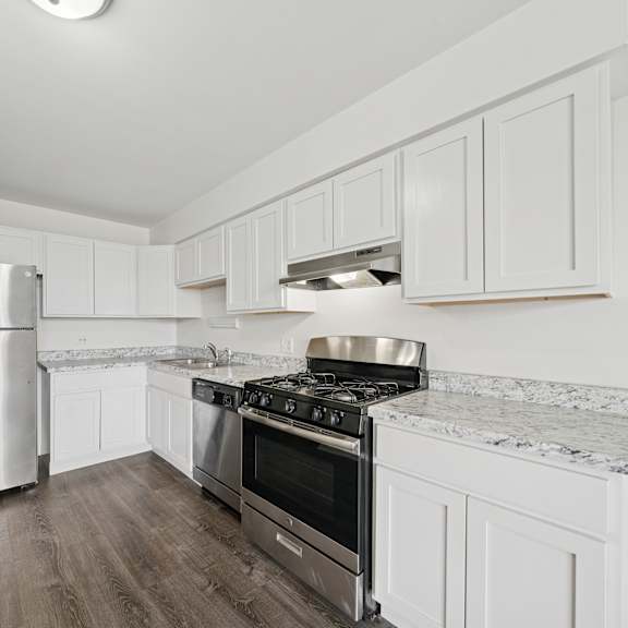 a kitchen with white cabinets and a stainless steel refrigerator.