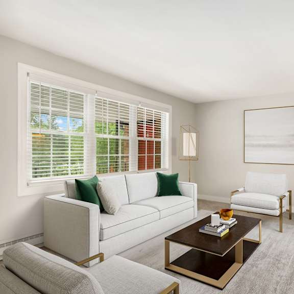 a living room with a white couch, a coffee table, and a window with blinds.