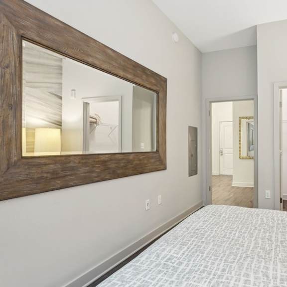 a bedroom with a bed and a mirror on the wall