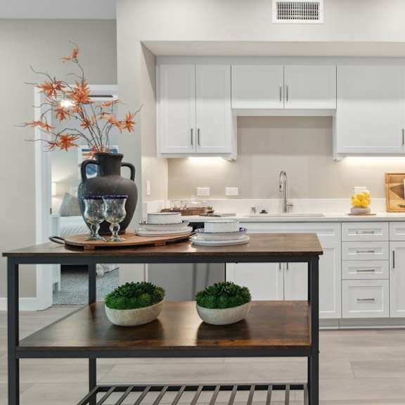 a kitchen with white cabinets and an island at arrive temecula