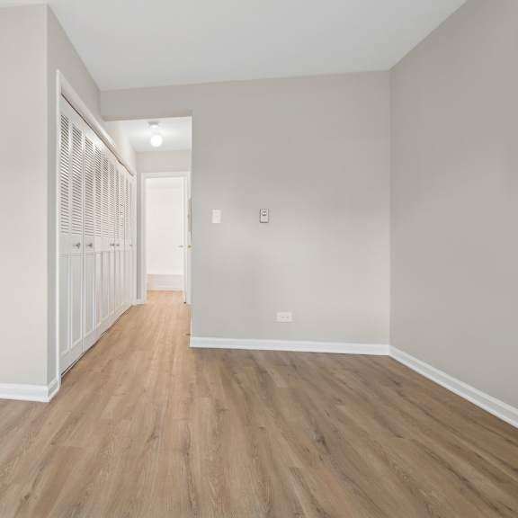 a long hallway with wood floors and white walls.