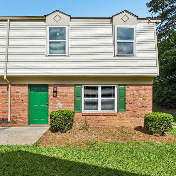 a house with a green door and a grey roof.