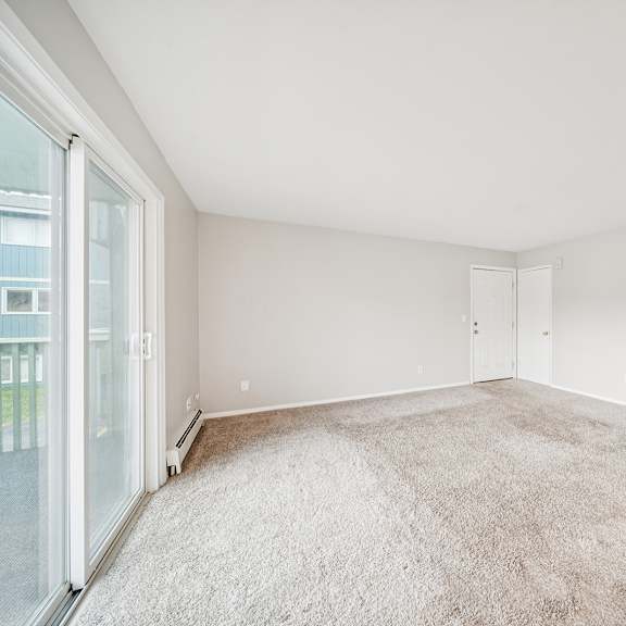 a large, empty room with a carpeted floor and white walls.