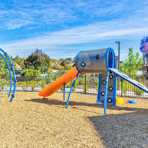 a playground with a blue slide and a yellow slide.