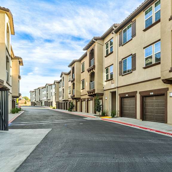 a row of apartment buildings with garages on the side.