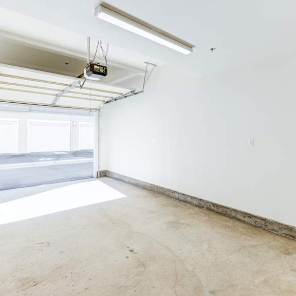 a large empty room with a window and a white wall.