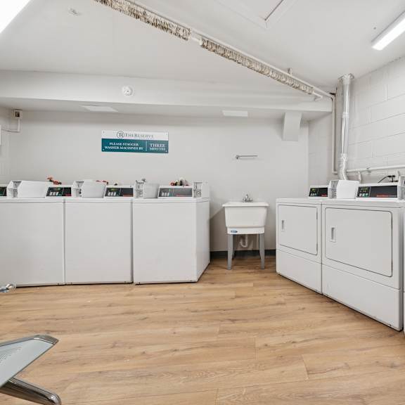 a room with white cabinets and a wooden floor.