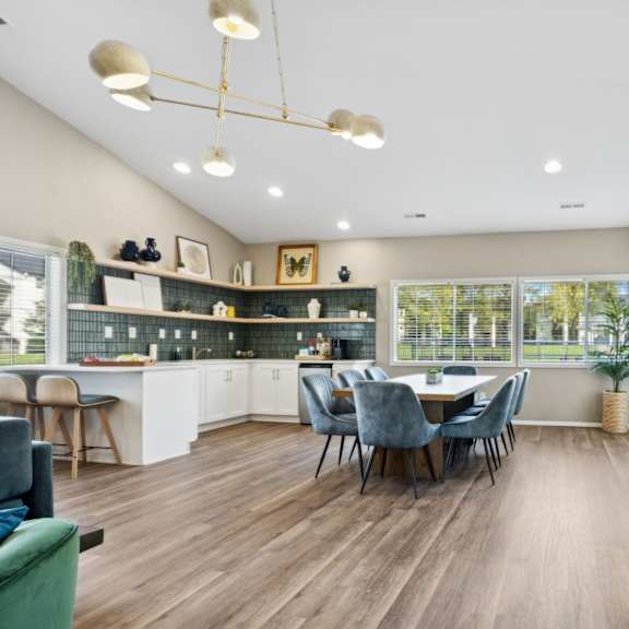 a well-lit room with a pool table and a dining table with chairs.