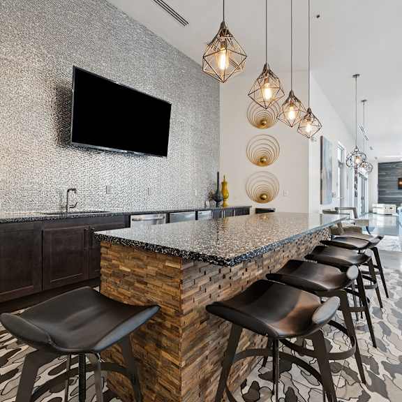 a modern table with a stone counter and black stools.