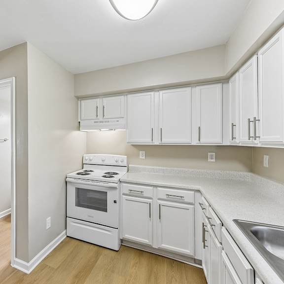 a kitchen with white cabinets and appliances.