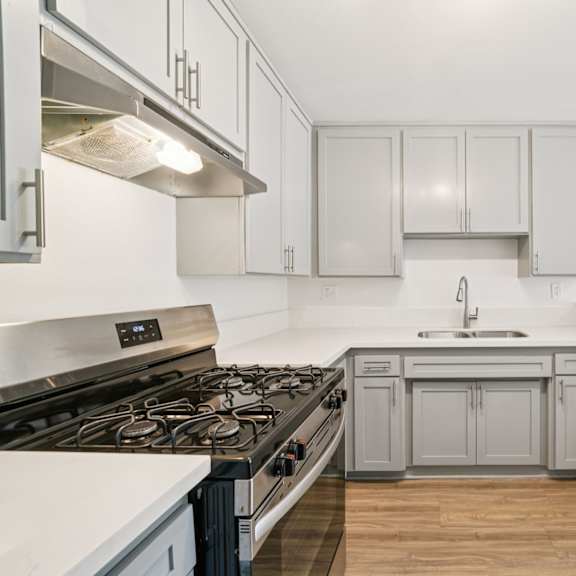 a kitchen with a stove top oven and a sink.