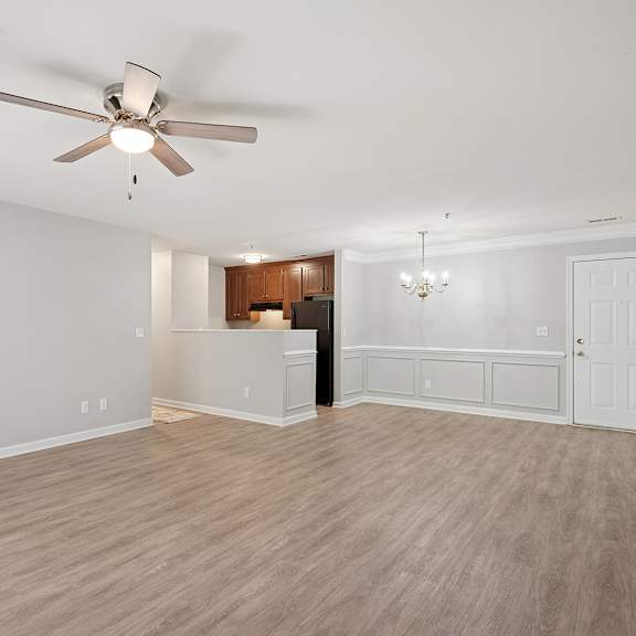 a room with a ceiling fan and wooden flooring.