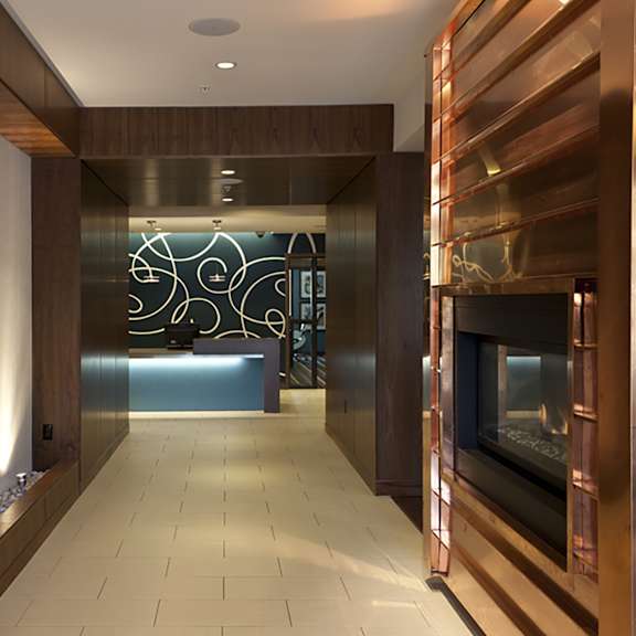 a hallway with a fireplace and artwork on the wall.