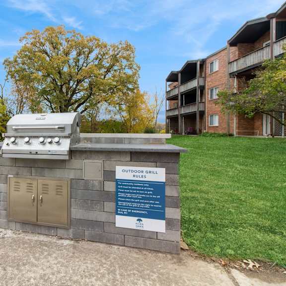 a barbecue grill sits on a brick structure in the middle of a grass field at river oaks, north aurora, il