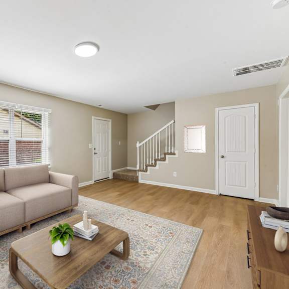 a living room with a couch, a coffee table, and a rug.