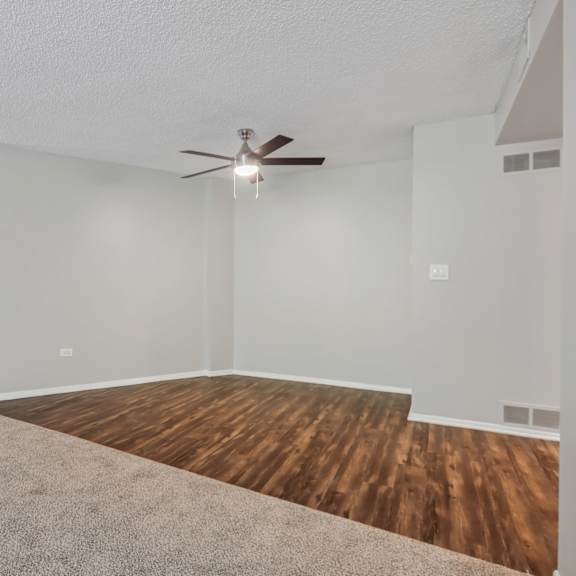 a room with a ceiling fan and a wooden floor.