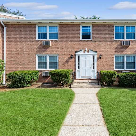 the front of a brick house with a white front door