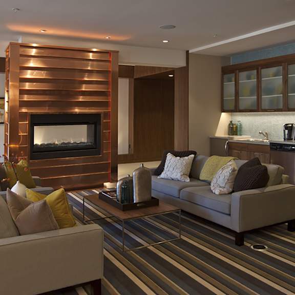 a modern living room with a fireplace and a striped rug.