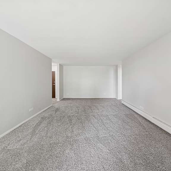 a long hallway with a carpeted floor and white walls.