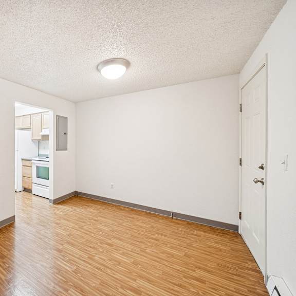 a room with white walls and wooden flooring.