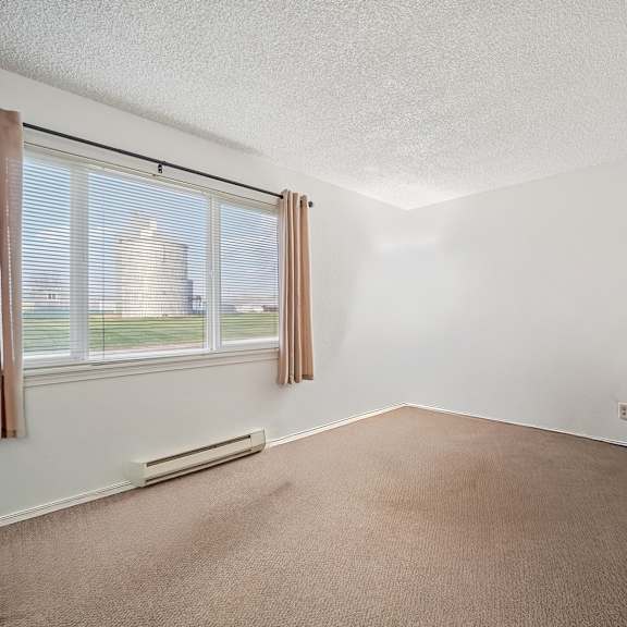 a room with a window and a carpeted floor.