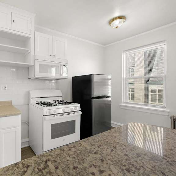 a kitchen with white cabinets and a granite countertop at pleasant oak apartments, oak park, il, 60302