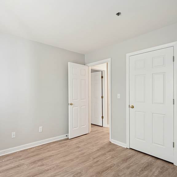 a room with two doors and a wooden floor.