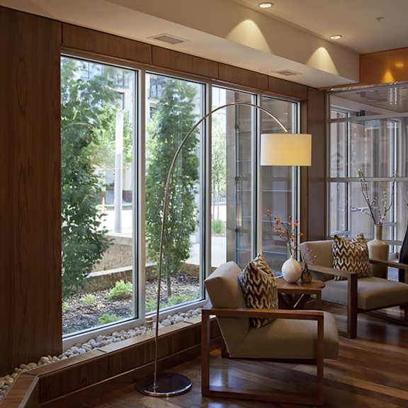 a living room with a large window and a wooden wall.