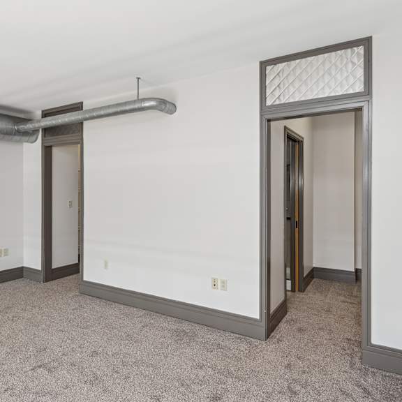 a room with a carpeted floor and a doorway leading to another room.