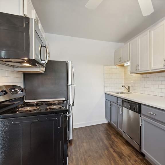 a kitchen with white cabinets and black appliances at the hinsdale, hinsdale, illinois
