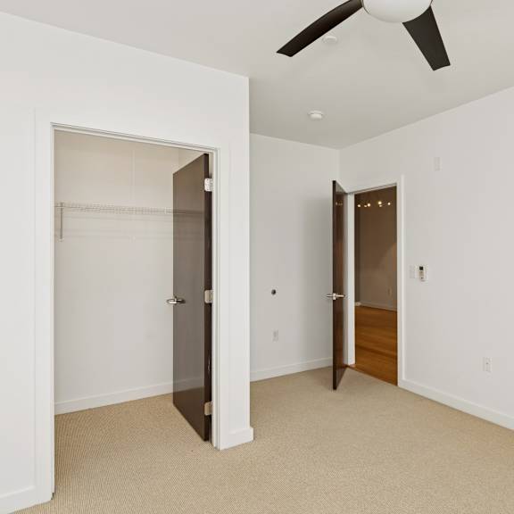 a room with a ceiling fan and two doors.
