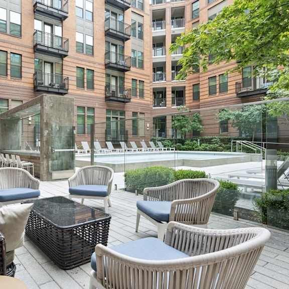 a patio with chairs and a table in front of a building