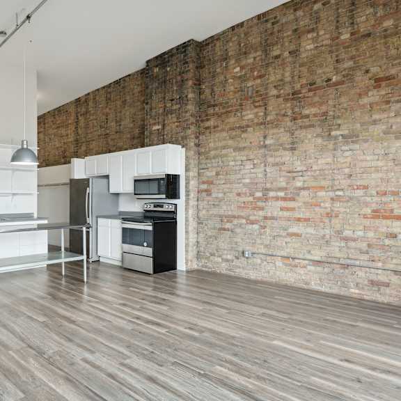 a kitchen and dining area in a 555 waverly unit at gaar scott historic lofts, minneapolis, minnesota