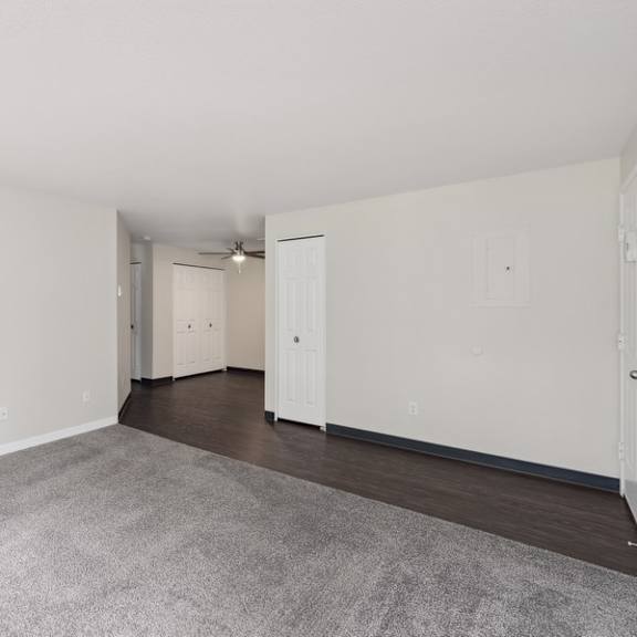 an empty living room with white walls and wood flooring at sundial apartments, wilsonvile, oregon