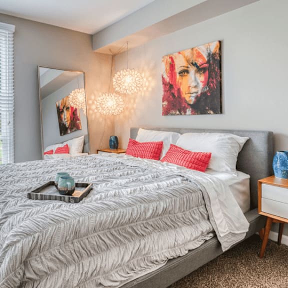 a bedroom with a large bed and a large window at the view apartments st charles, illinois
