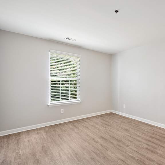 a room with a window and wooden flooring.